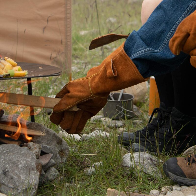 キャンプグローブを使ってたき火をする男性